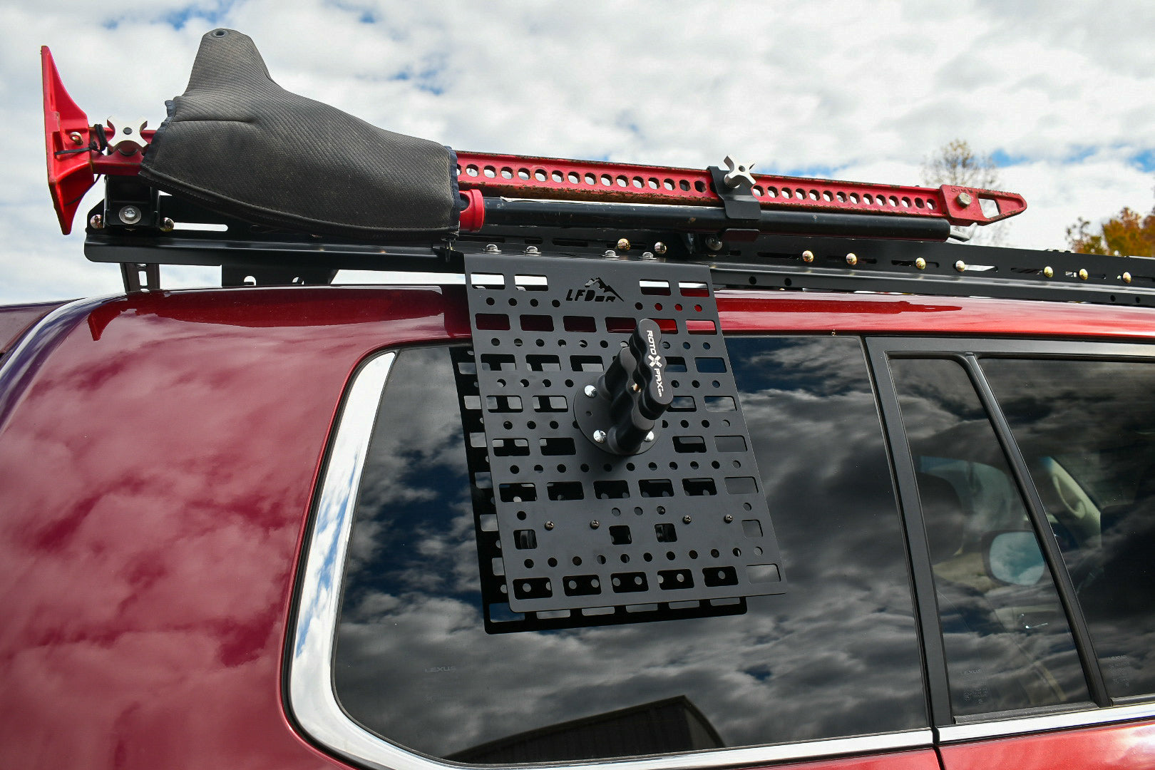 A black multi-purpose window panel mounted on the rear window of a vehicle, with suction cups and mounting hardware visible.