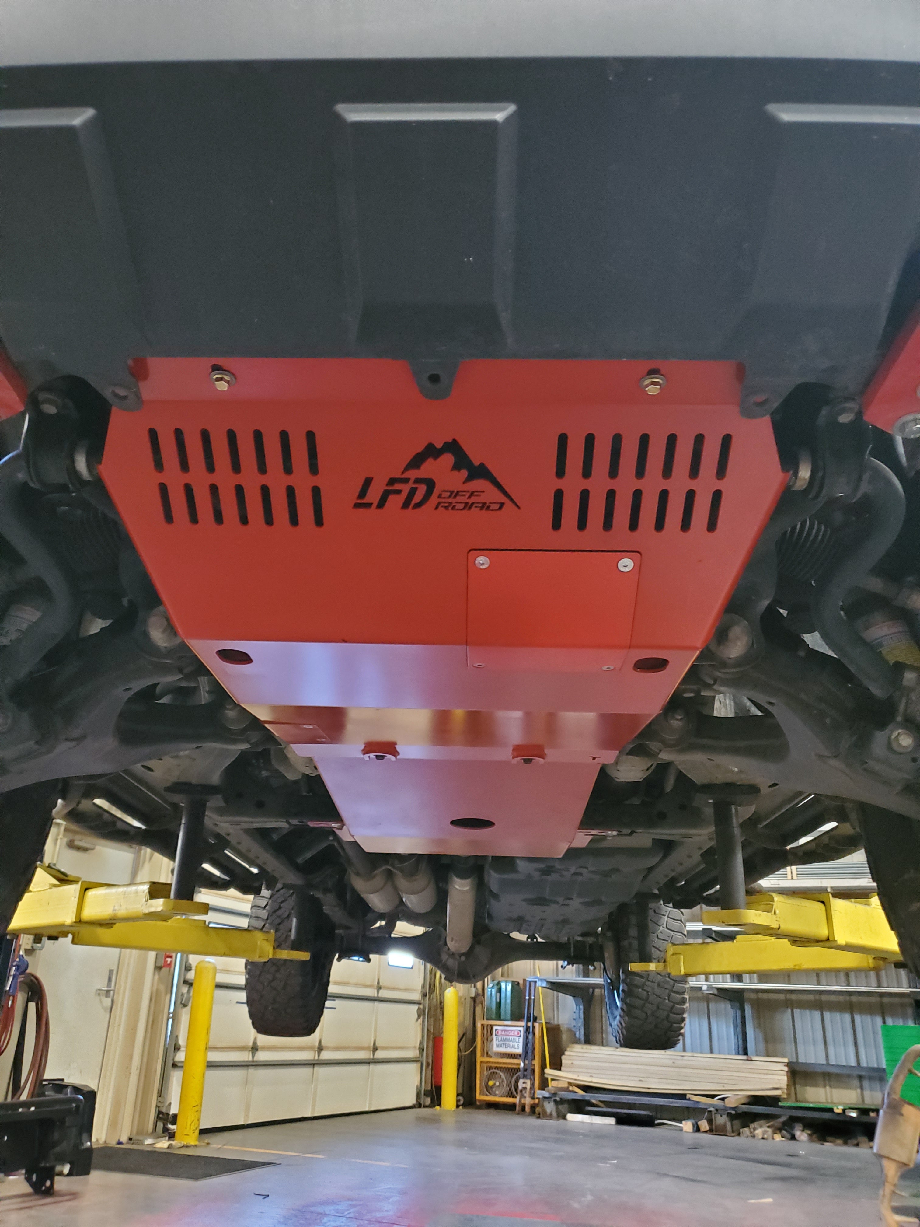 A red front skid plate on a 2nd Gen Tundra truck, showing the undercarriage with the plate installed.