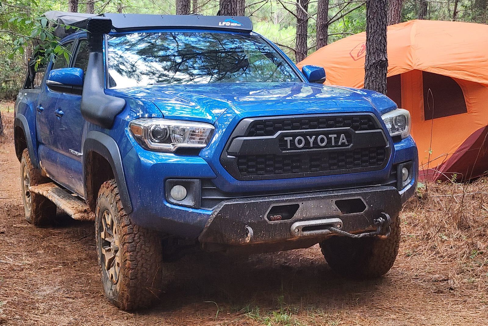 A blue Toyota Tacoma with a custom hybrid front bumper designed for 3rd Gen Tacoma models (2016-2023).