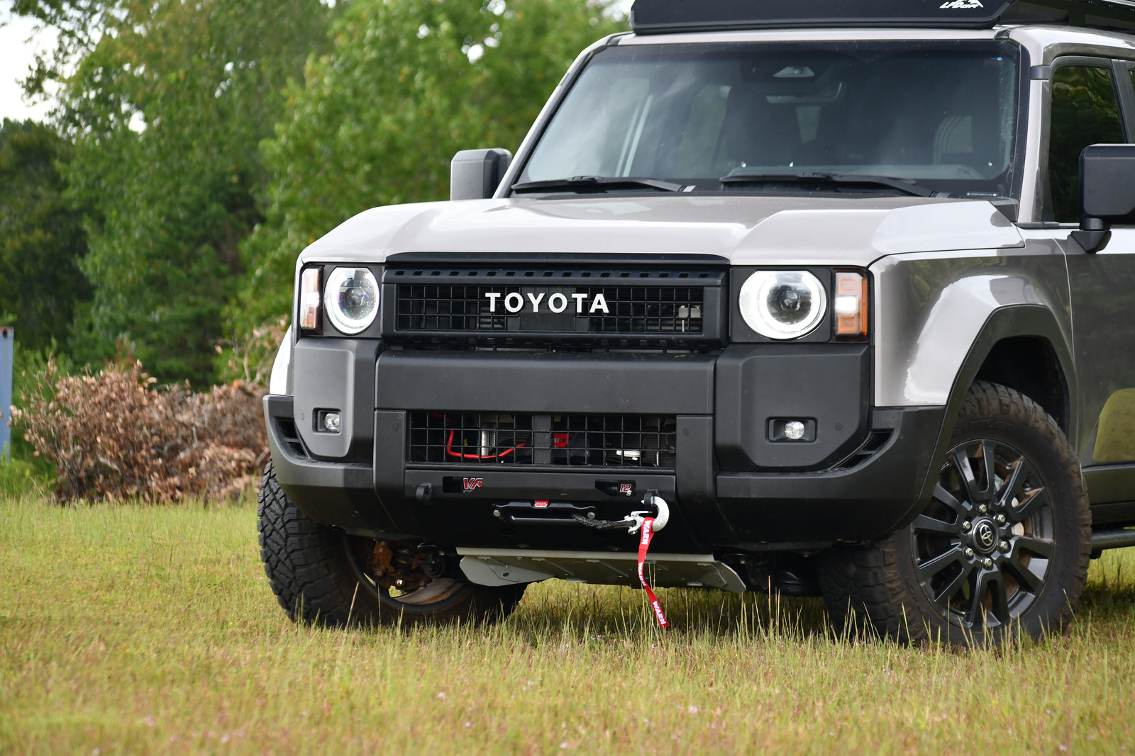A black front winch bumper designed for the Land Cruiser 250, featuring a metal center bumper and recovery points.