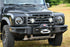 Front view of a black Ineos Grenadier vehicle featuring a center winch bumper.