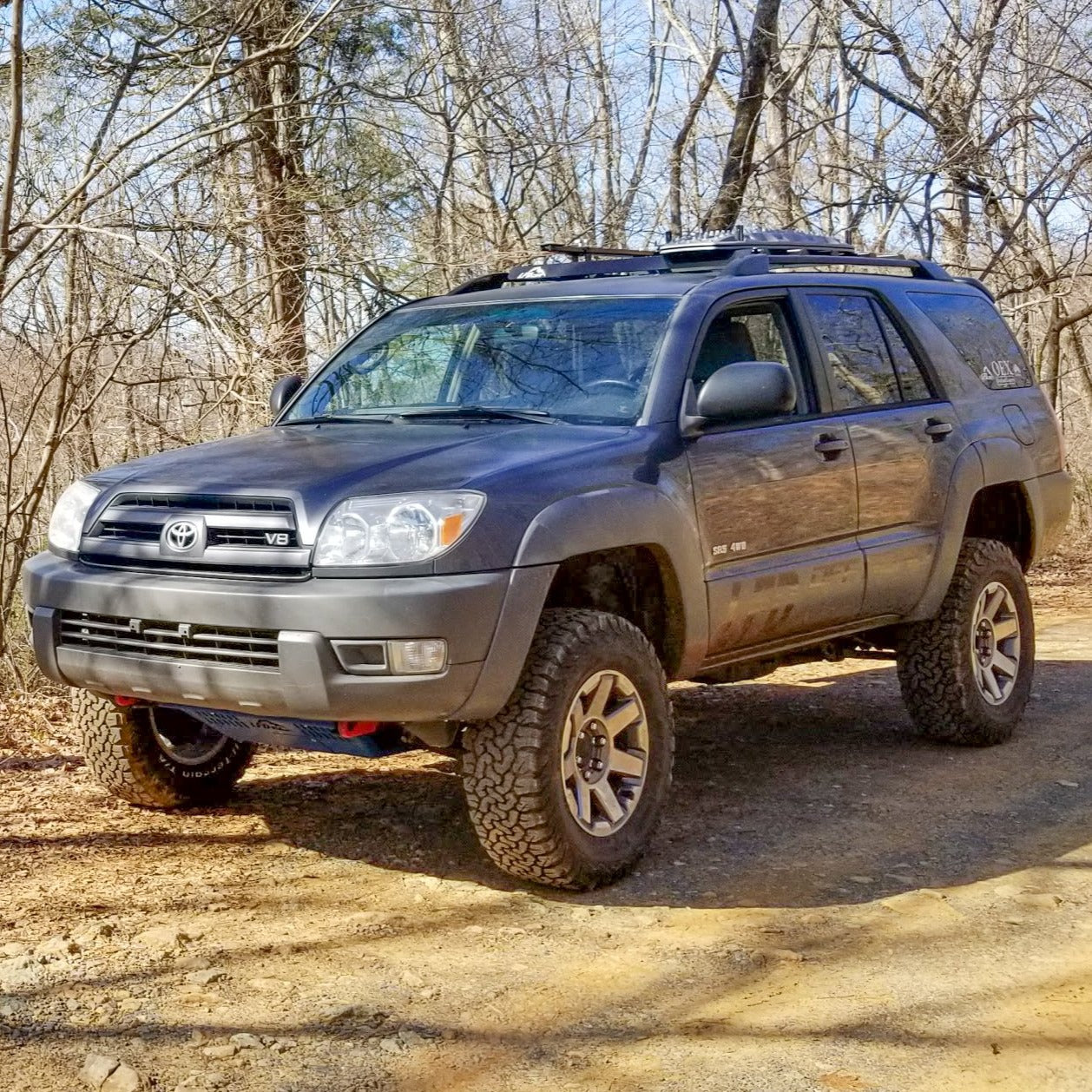 A 4th Gen 4Runner SUV with the Ruggedized Crossbar installed on the roof rails, set against a natural backdrop.