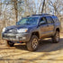 A 4th Gen 4Runner SUV with the Ruggedized Crossbar installed on the roof rails, set against a natural backdrop.