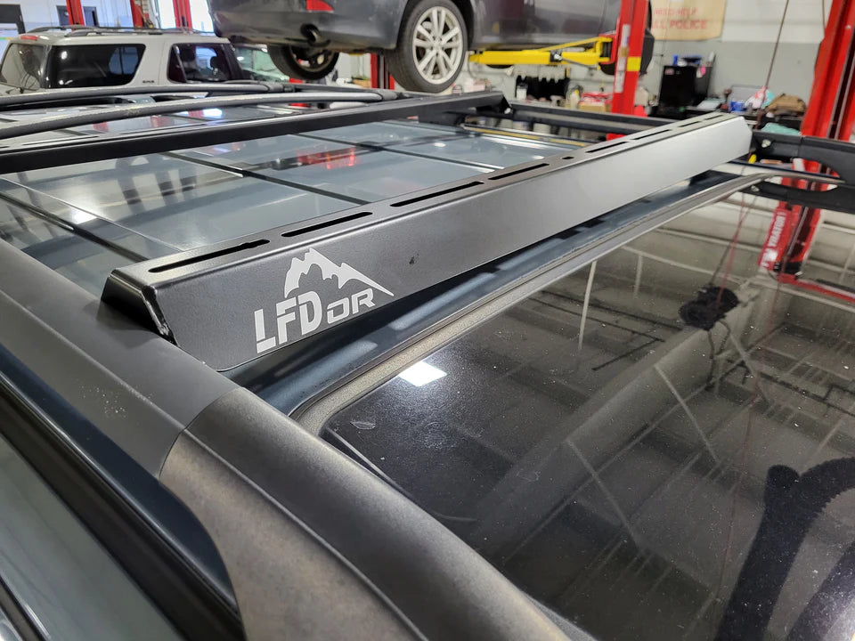 Integrated Wind Fairing Ruggedized Crossbar mounted on a vehicle roof rack, with a black powder-coated finish and the LFD OR logo visible.