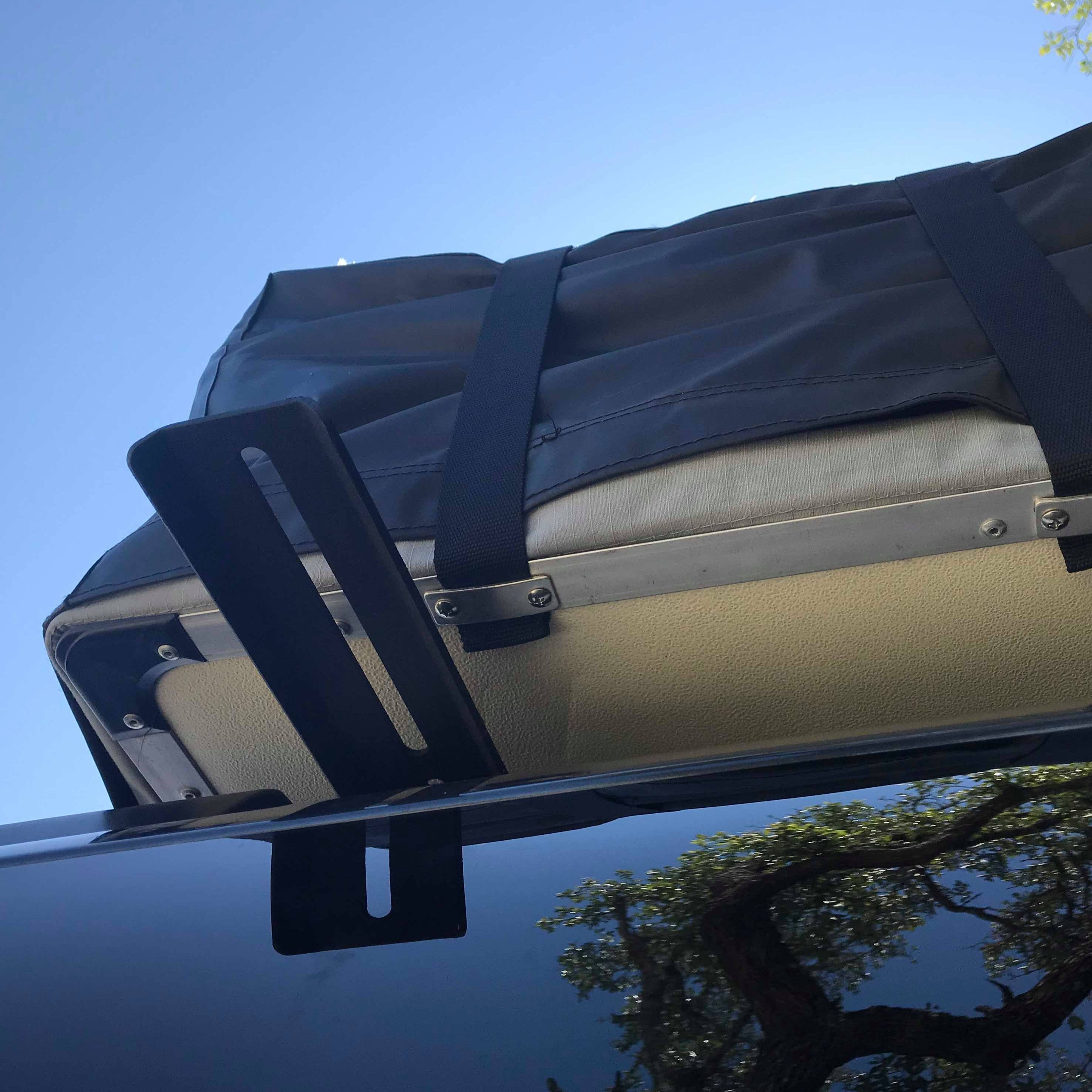 A black powder coated steel crossbar extension mounted on a vehicle roof rack, with a rooftop tent and straps visible in the background.
