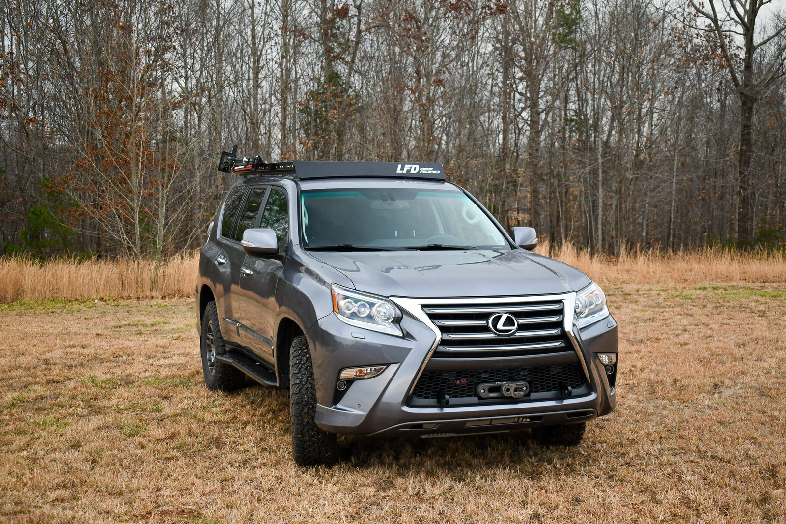 A Lexus GX460 SUV equipped with a full roof rack in an outdoor setting.