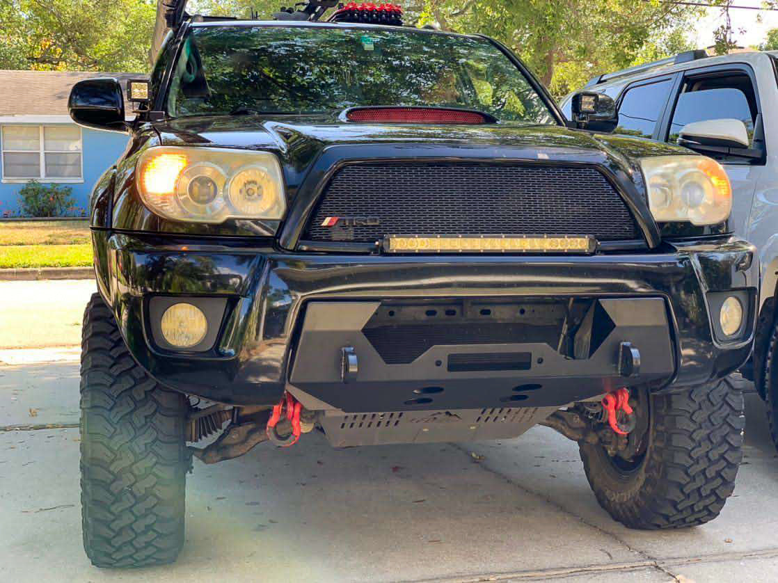 A black hybrid front bumper designed for a 4th gen 4Runner, showing the bumper's mounting points and recovery points in relation to the vehicle's frame.