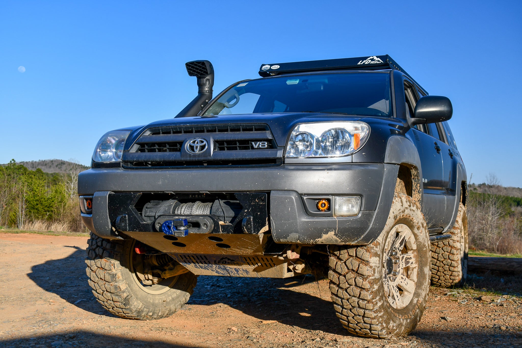 A black hybrid front bumper designed for a 4th gen 4Runner, showing the bumper's mounting points and recovery points in relation to the vehicle's frame.