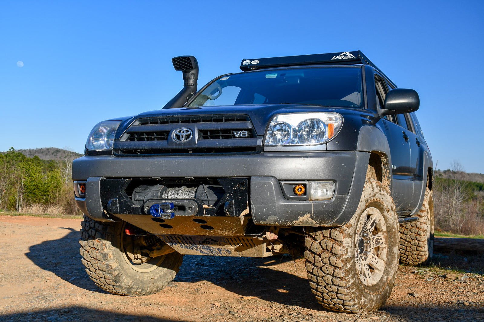 A black hybrid front bumper designed for a 4th gen 4Runner, showing the bumper's mounting points and recovery points in relation to the vehicle's frame.