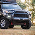 Front view of a 5th Gen 4Runner with an adjustable hidden winch mount installed on the bumper, with red fairleads attached.