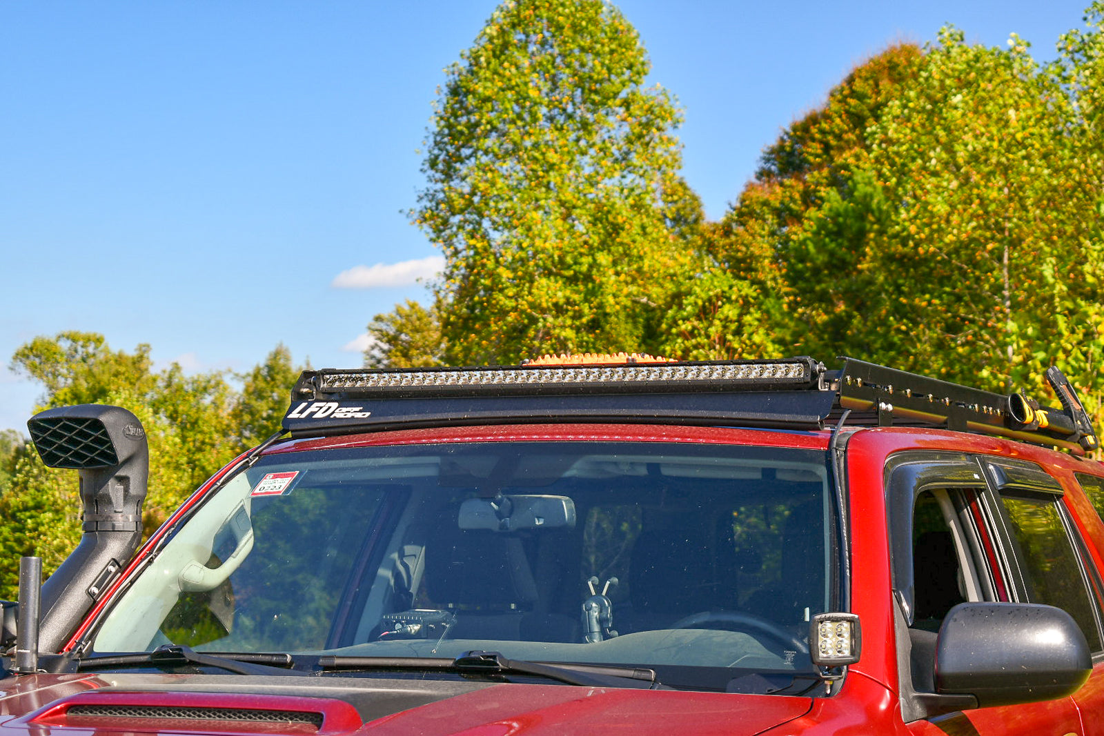 A black stainless steel light bar fairing mounted on a vehicle roof rack